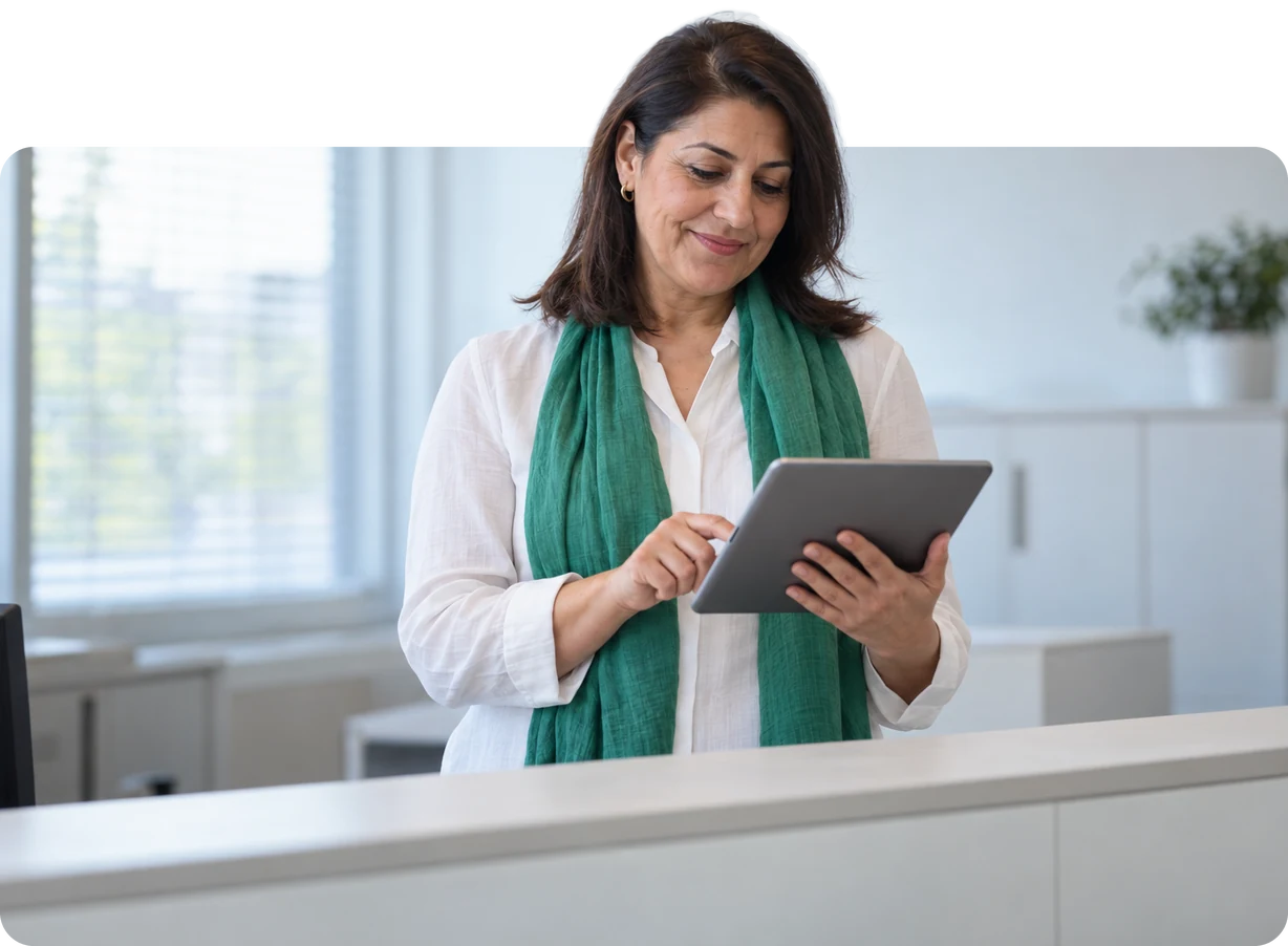 School secretary confirming a sick note on her tablet in the morning