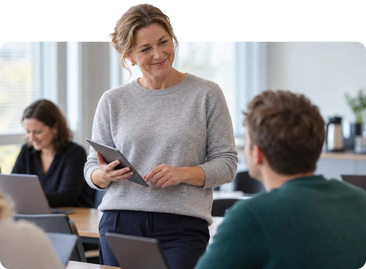 Deputy head with a tablet talking to a colleague in the staff room